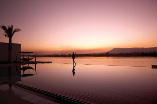 Infinity pool at sunset with views of the Nile and West Bank